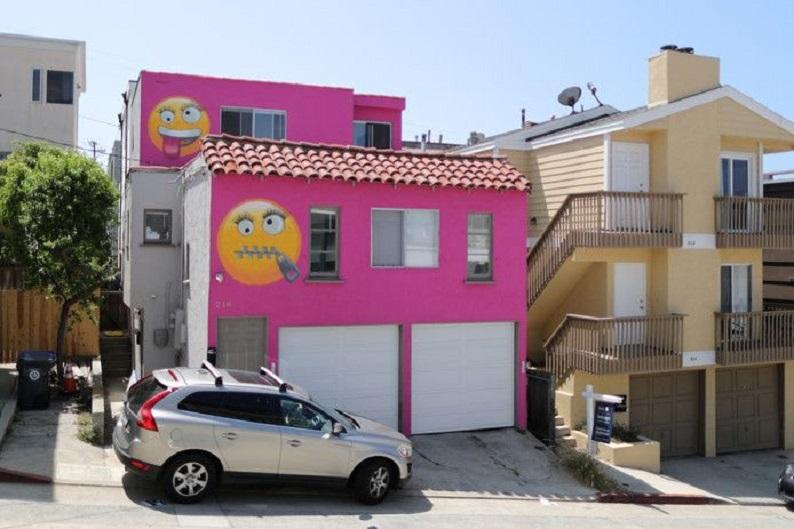 Bright pink house decorated with emojis is result of neighbor’s quarrel